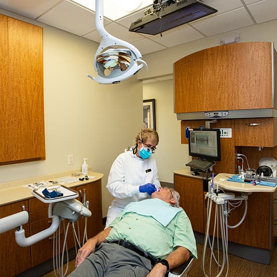 Dr. Carlson and a male patient during a dental procedure 